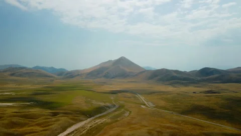 4K drone flight forward over yellow-green valley with road and cars Stock Footage 315192256