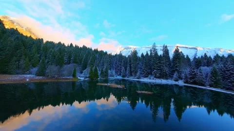 4K Drone Flight Over Alpine Lake Into Snow Forest Stock Footage 330050048