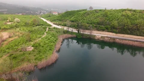 4K Drone Fly Forward Along Lakeside Road with Passing Vehicles Stock Footage 335769565