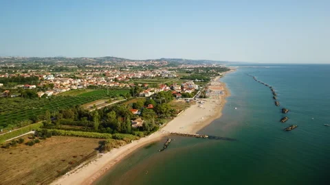 4K drone flying backward over beach, coastal city, and hills in morning light Stock Footage 315195524
