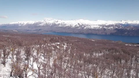 4K drone flying fast over a snowy mountain with a lake at the background Stock Footage 249006962