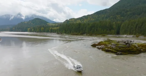 4k Drone Flying Over Approaching Fishing Boat In Evergreen Mountain River Valley Stock Footage 264662179