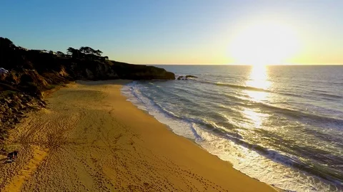 4k Drone flying over sand beach pacific ocean rocks torward sunset Stock Footage 73241694