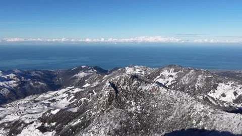 4K Drone Flying From Snowy Mountains Toward Blue Sea Under Clear Sky Vídeos de archivo 335487952