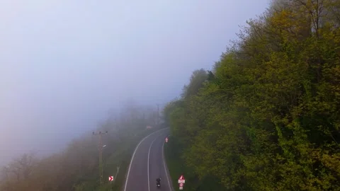 4K Drone Flying Through Fog Above Road as Motorcycle Passes Below Stock-Footage 339278292