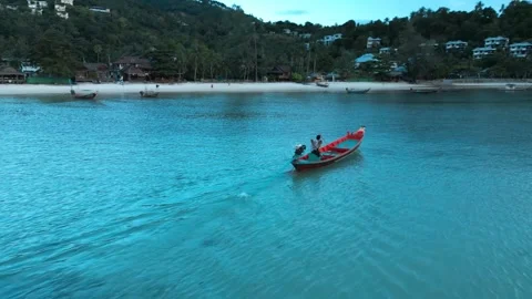 4K Drone Follow Shot of Local Fisherman Boat Approaching Tropical Beach 動画素材 310562453