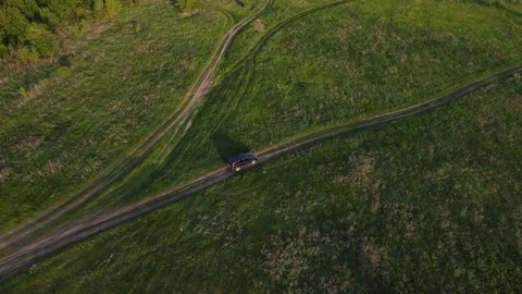 4K drone footage behind a moving car driving along a dirt road Stock Footage 164089092