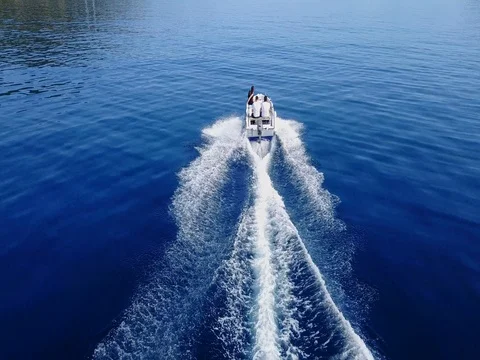 4K drone footage fly over speed motor boat wake people Stock Footage