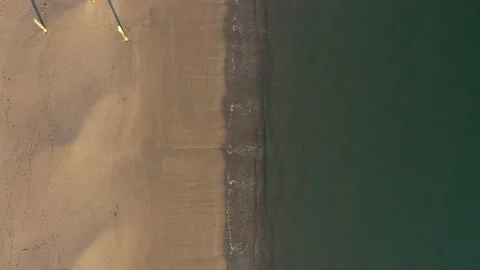 4K Drone looking down to a sandy beach shoreline on the Welsh coast 스톡 동영상 188543805