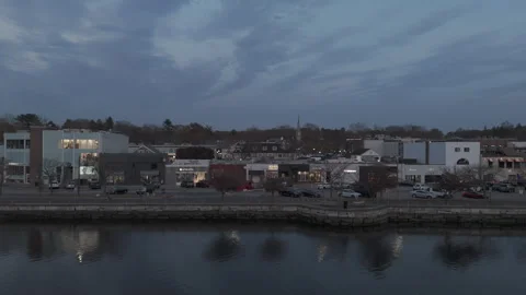 4k drone low angle moving right, luxury storefronts on river shoreline Stock Footage 291110489