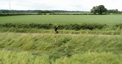 4K Drone of A Man Running on a Path  through Trees and Green Grass Meadows. Stock Footage 91231342