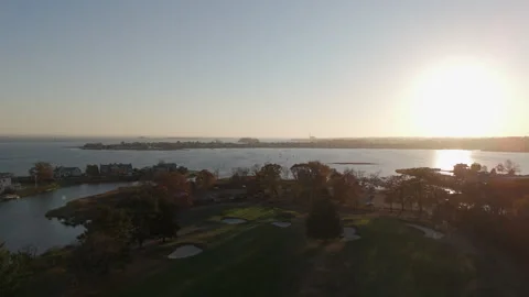 4k drone moving left to right over shoreline golf course at sunset Stock Footage 290948644