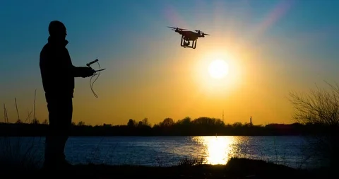 4K - Drone operator and drone silhouette. Quadcopter flies away Stock Footage 106683384