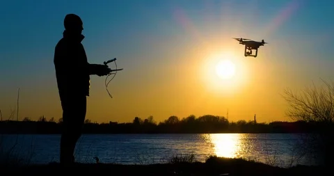 4K - Drone operator silhouette. Quadcopter flies up Stock Footage 106683256
