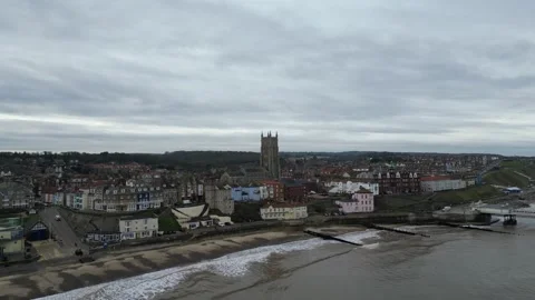 4K Drone Over Ocean Facing British Coastal Town and Church Stock Footage 297016527