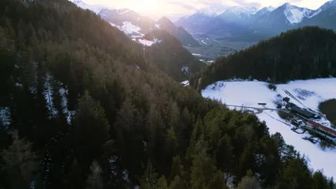 4K drone overflight over a snow-covered mountain forest at sunset 動画素材 301542188