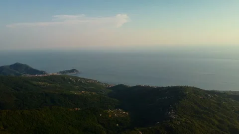 4K drone pan left to right over coastal city and forested mountains at sunset Stock Footage 315192823