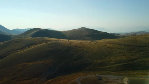 4K drone pan left to right over yellow mountain hills with campers, tents Stock Footage 315193673