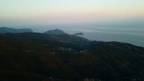 4K drone pan left to right over coastal city and forested mountains at sunset Stock Footage 315194864