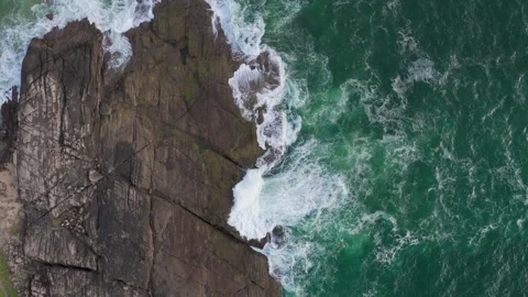 4K Drone Push In over Rocky Cliff with Foamy Ocean Waves in Evening Stock Footage 316825507