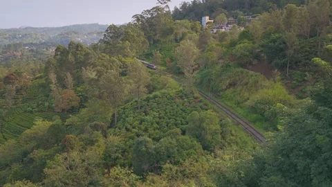 4K Drone Push In Shot of Train Approaching Through Green Mountains Stock Footage 325886415