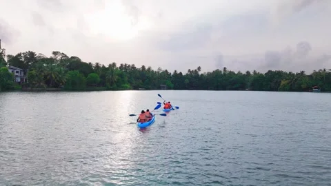 4K Drone Push-In Tracking Shot of Kayakers Moving Across Lagoon in the Evening Stock Footage 316084619