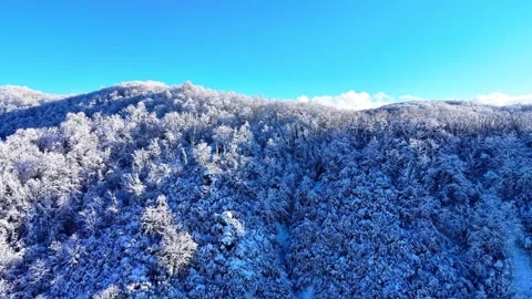 4K Drone Reaching Snowy Mountain Summit with Sunlight Over Frozen Landscape Vídeo Stock 335315984