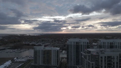 4k drone rotate left to right showcasing waterfront high rise apartments at dusk Stock Footage 291223586
