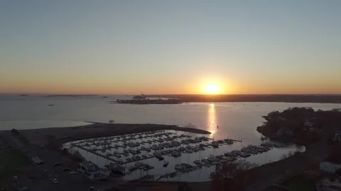 4k drone rotating right to left showcasing boats docked in harbor during sunset Stock Footage 290949230