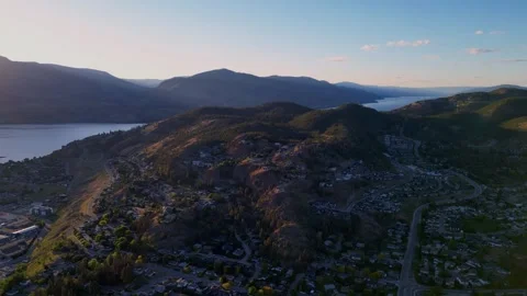 4k drone shot of Knox Mountain rising above Kelowna at sunset with warm orange Stock Footage 336900495