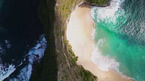 4K Drone shot of ocean wave washing over Kelingking Beach in Nusa Penida Video Stock Footage 275797102