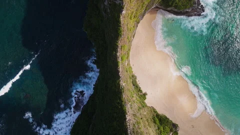 4K Drone shot of ocean wave washing over Kelingking Beach in Nusa Penida Video Stock Footage 275799336