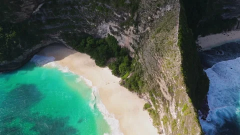 4K Drone shot of ocean wave washing over Kelingking Beach in Nusa Penida Video Stock Footage 276198439