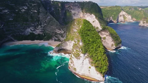 4K Drone shot of ocean wave washing over Kelingking Beach in Nusa Penida Video Stock Footage 276198464