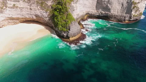 4K Drone shot of ocean wave washing over Kelingking Beach in Nusa Penida Video Stock Footage 276198613