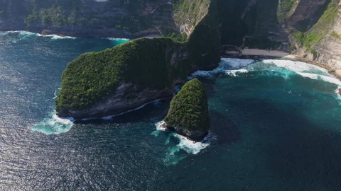 4k Drone shot of ocean wave washing over Kelingking Beach in Nusa Penida Video Stock Footage 276198983