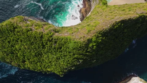 4K Drone shot of ocean wave washing over Kelingking Beach in Nusa Penida Video Stock Footage 276198991