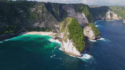 4K Drone shot of ocean wave washing over Kelingking Beach in Nusa Penida Video Stock Footage 276198995
