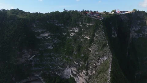 4K Drone shot of ocean wave washing over Kelingking Beach in Nusa Penida Video Stock Footage 276236334