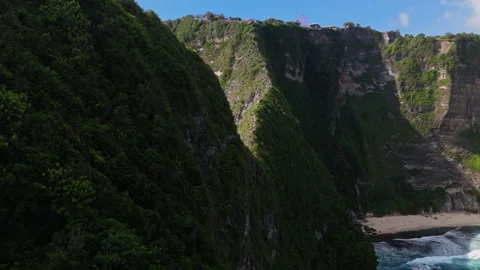 4K Drone shot of ocean wave washing over Kelingking Beach in Nusa Penida Video Stock Footage 276236654