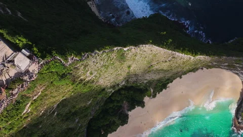 4K Drone shot of ocean wave washing over Kelingking Beach in Nusa Penida Video Stock Footage 276237913