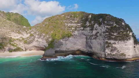 4K Drone shot of ocean wave washing over Kelingking Beach in Nusa Penida Video Stock Footage 276237930