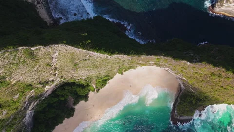 4K Drone shot of ocean wave washing over Kelingking Beach in Nusa Penida Video Stock Footage 276238244