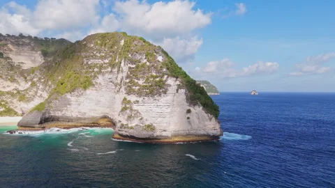 4K Drone shot of ocean wave washing over Kelingking Beach in Nusa Penida Video Stock Footage 276238250