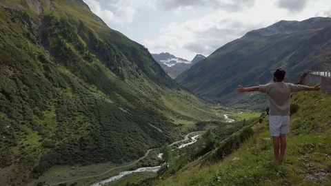 4K drone shot of young man standing in nature arms outstretched, Swiss Alps 스톡 동영상 89042581