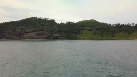 4K Drone Side View of Mt. Songaksan (송악산), Jeju Volcanic Island Stock Footage 143864040