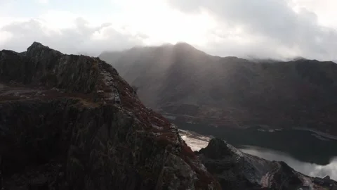 4K drone of sun rays over Yr Wyddfa / Snowdonia from Dinorwic Quarry, Wales 動画素材 321609706