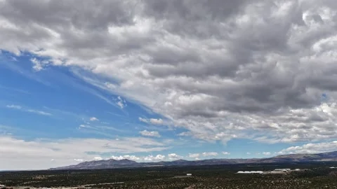 4K Drone Timelapse of Moving Dramatic Clouds over Desert Mesas and a Distant Видео 334663685