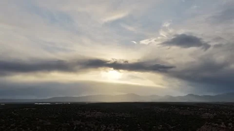 4K Drone Timelapse of Streaming Clouds and Intermittent Sun Rays Over Desert Stock Footage 335921081