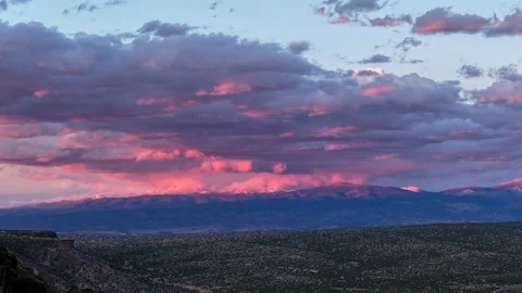 4K Drone Timelapse of Sunset Light Moving across a Snowy Mountain Peak during a Stockbeeldmateriaal 335008787
